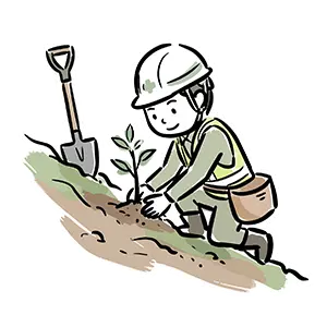 斜面にしゃがみ込みスコップの横で小さな苗木を植林するヘルメット姿の作業員